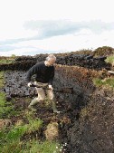 Steve Chapman cuts peat under the watchful eye of a local peat cutter